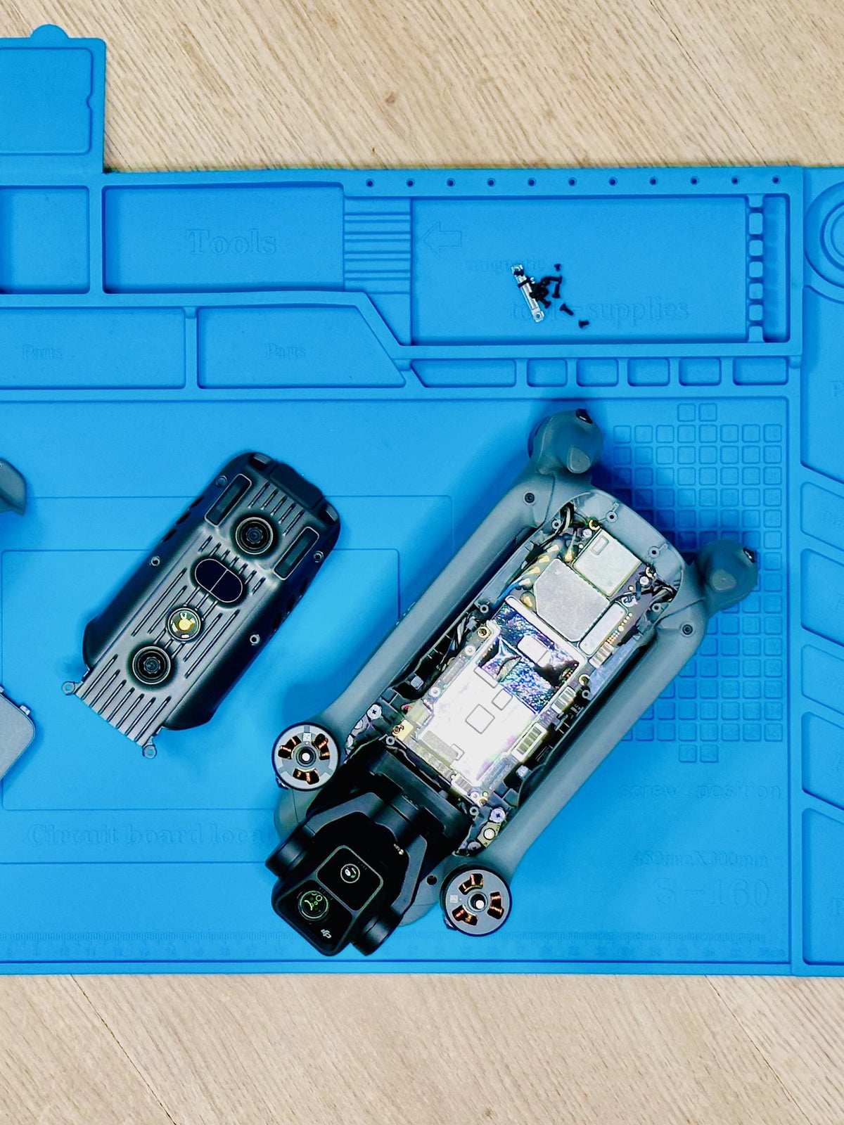 Geöffnete DJI Air 3 mit ausgebauter Gimbal-Kamera und Akku auf der Reparaturmatte bei CopterTec.
