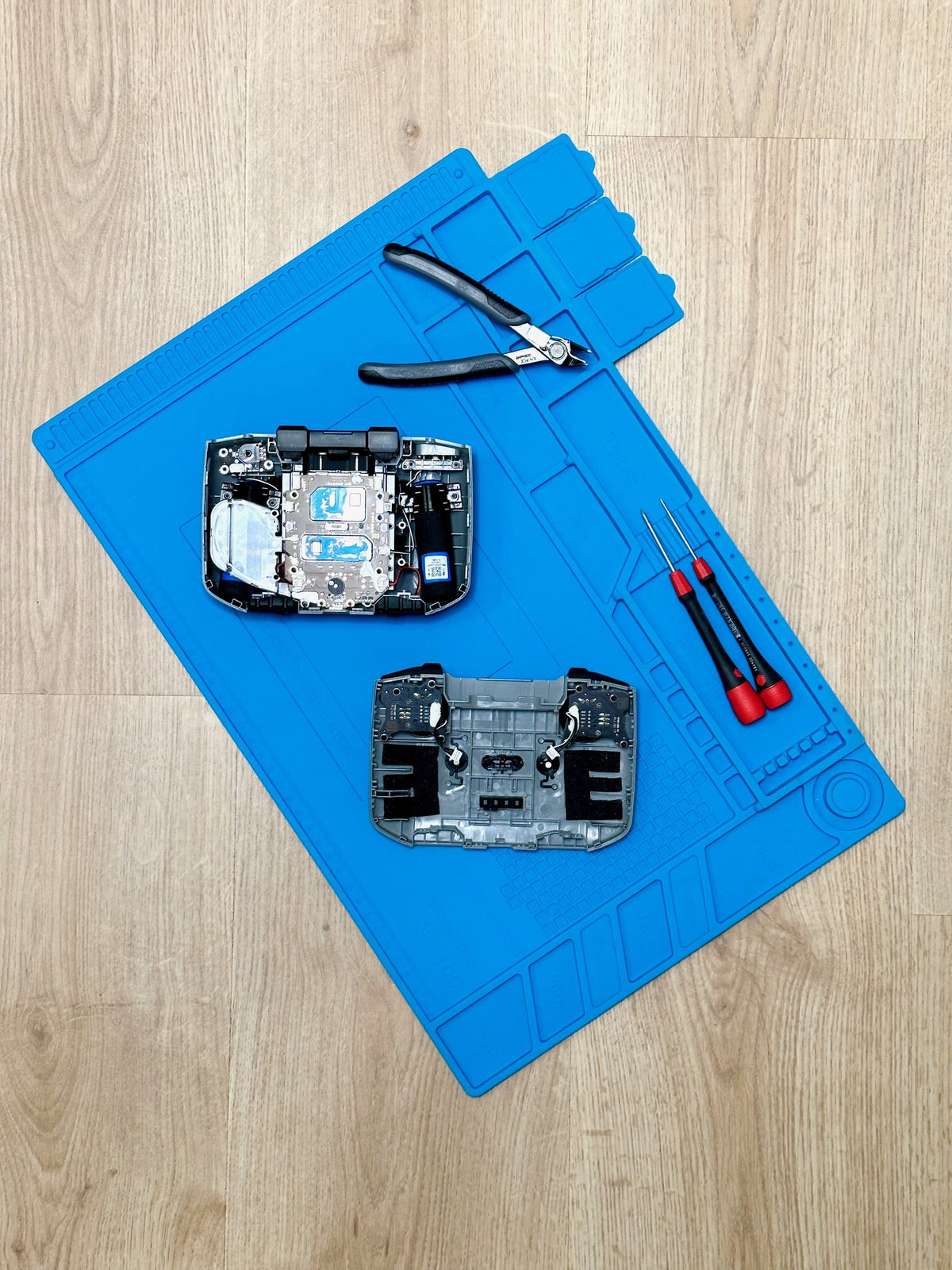 Geöffnete DJI Fernsteuerung (passend für Mini 2, Mini 3 und Mini 4 Pro) mit Werkzeug auf der Reparaturmatte bei CopterTec.