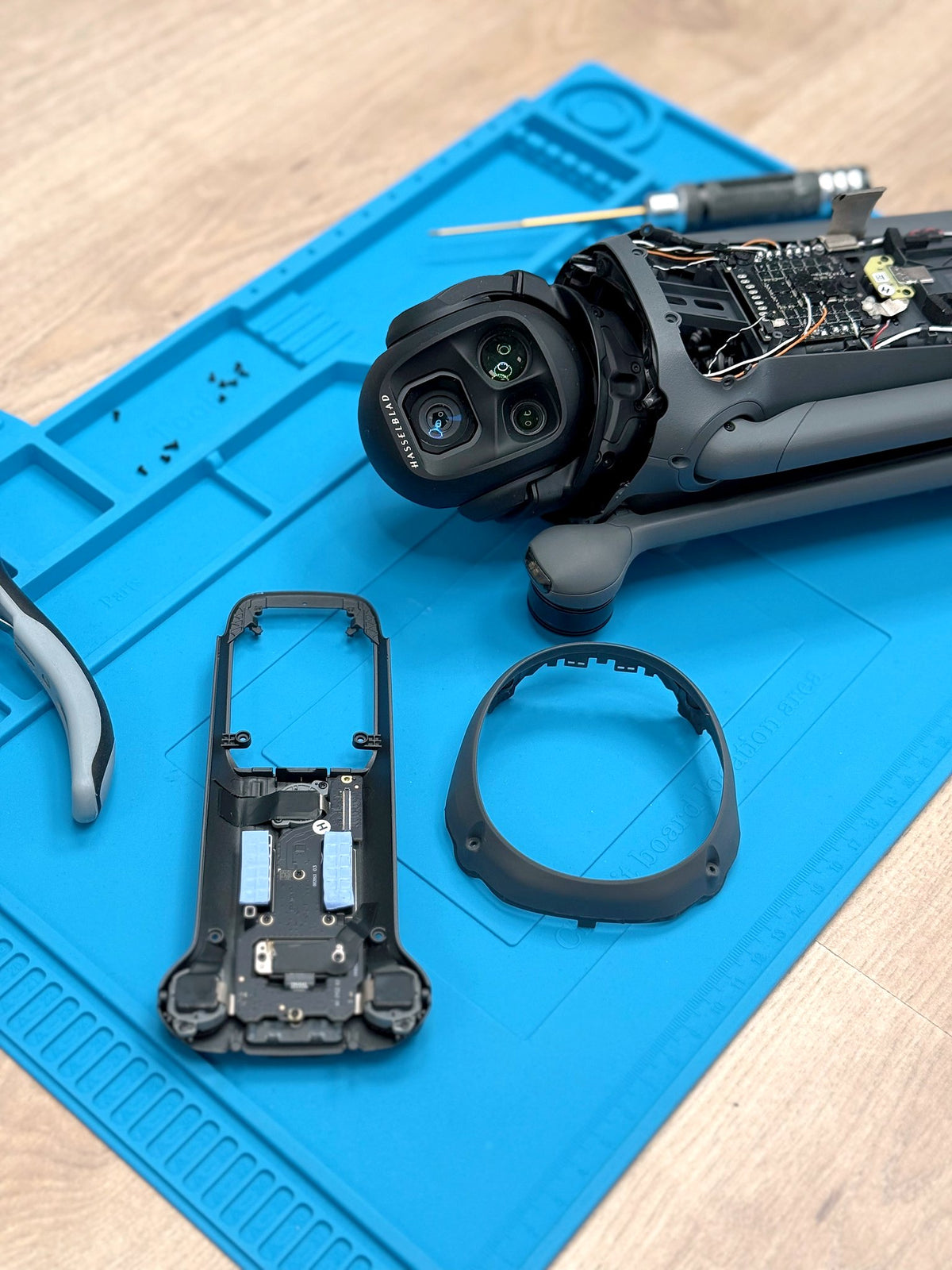 Für die Reparatur zerlegte DJI Mavic 4 Pro mit Kameramodul und Gehäuseteilen auf der Reparaturmatte bei CopterTec.