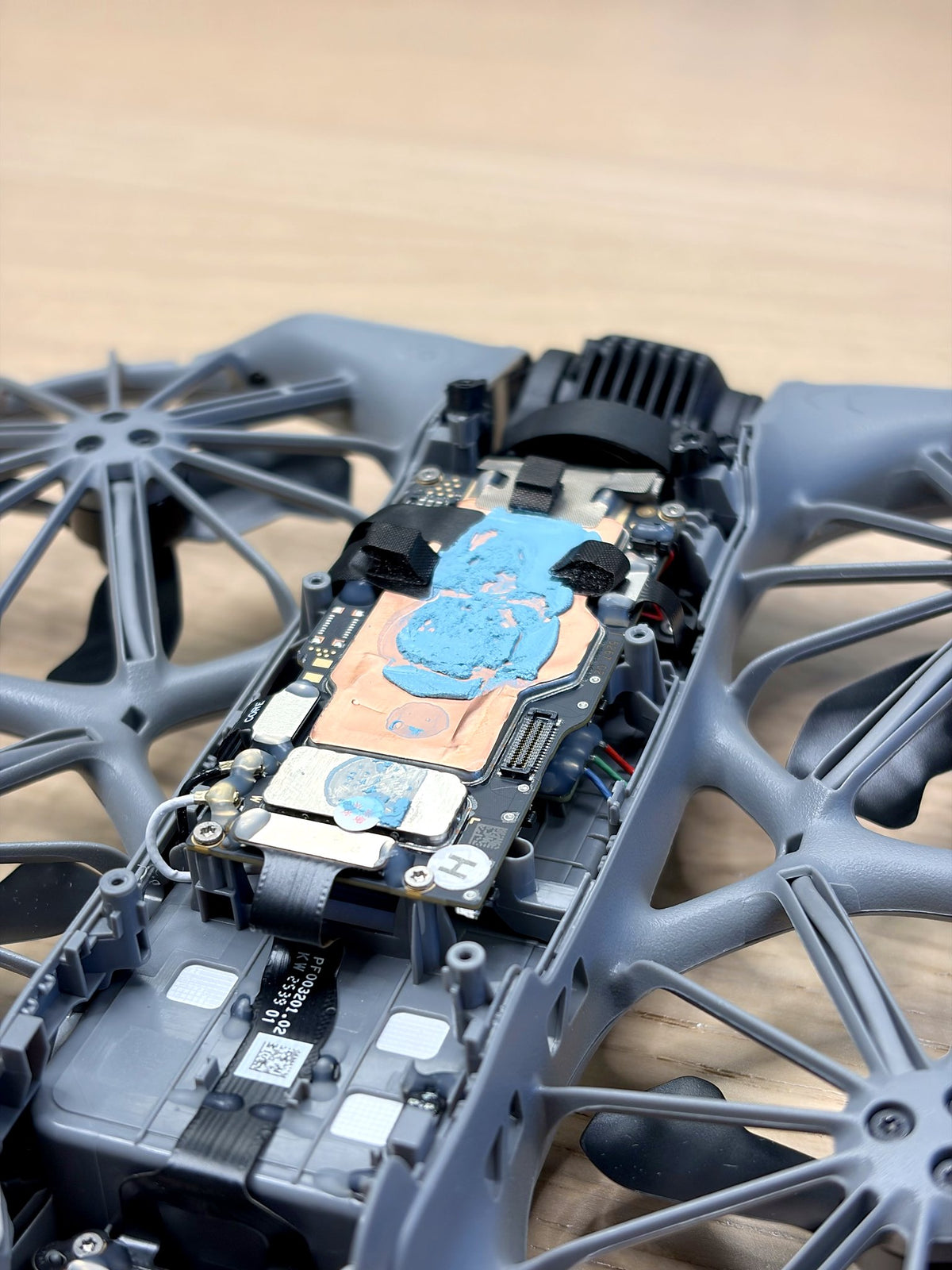 Geöffnete DJI Neo 2 mit frisch aufgetragener Wärmeleitpaste auf der Elektronik bei der Reparatur bei CopterTec.