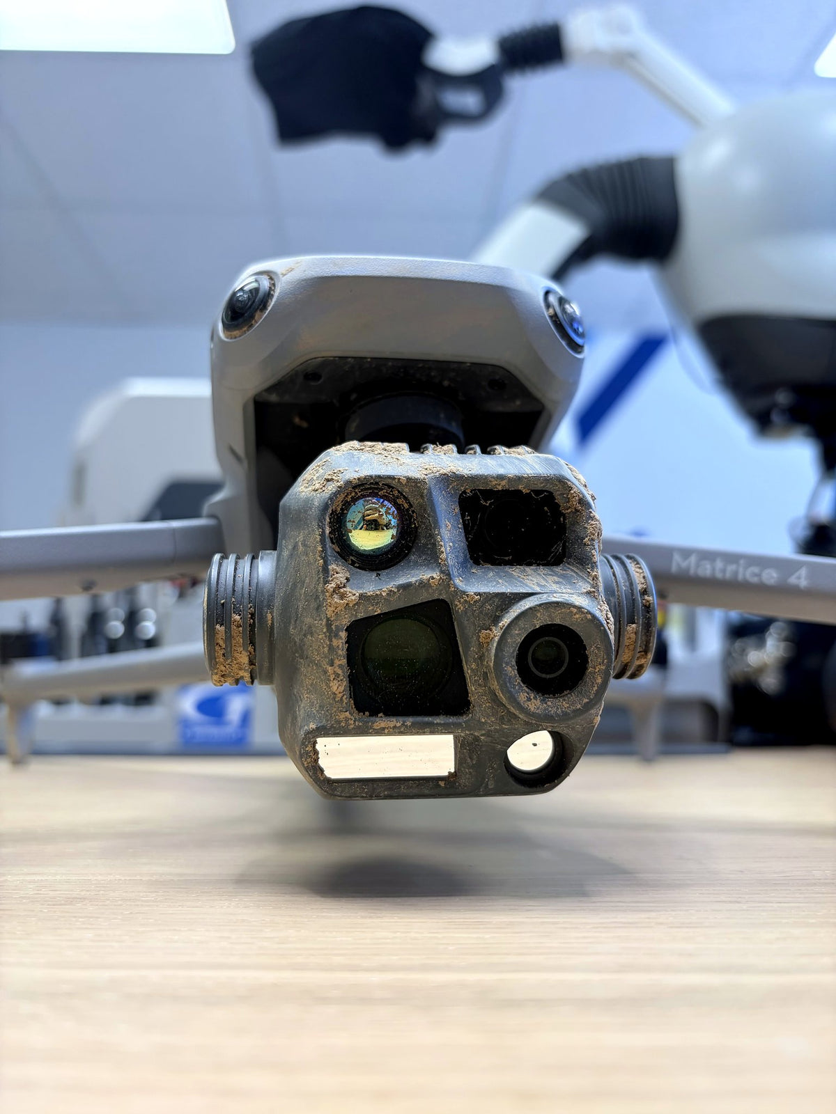 Verschmutzte Kamera einer DJI Matrice 4T bei der Eingangsprüfung vor der Reparatur in der CopterTec-Werkstatt.