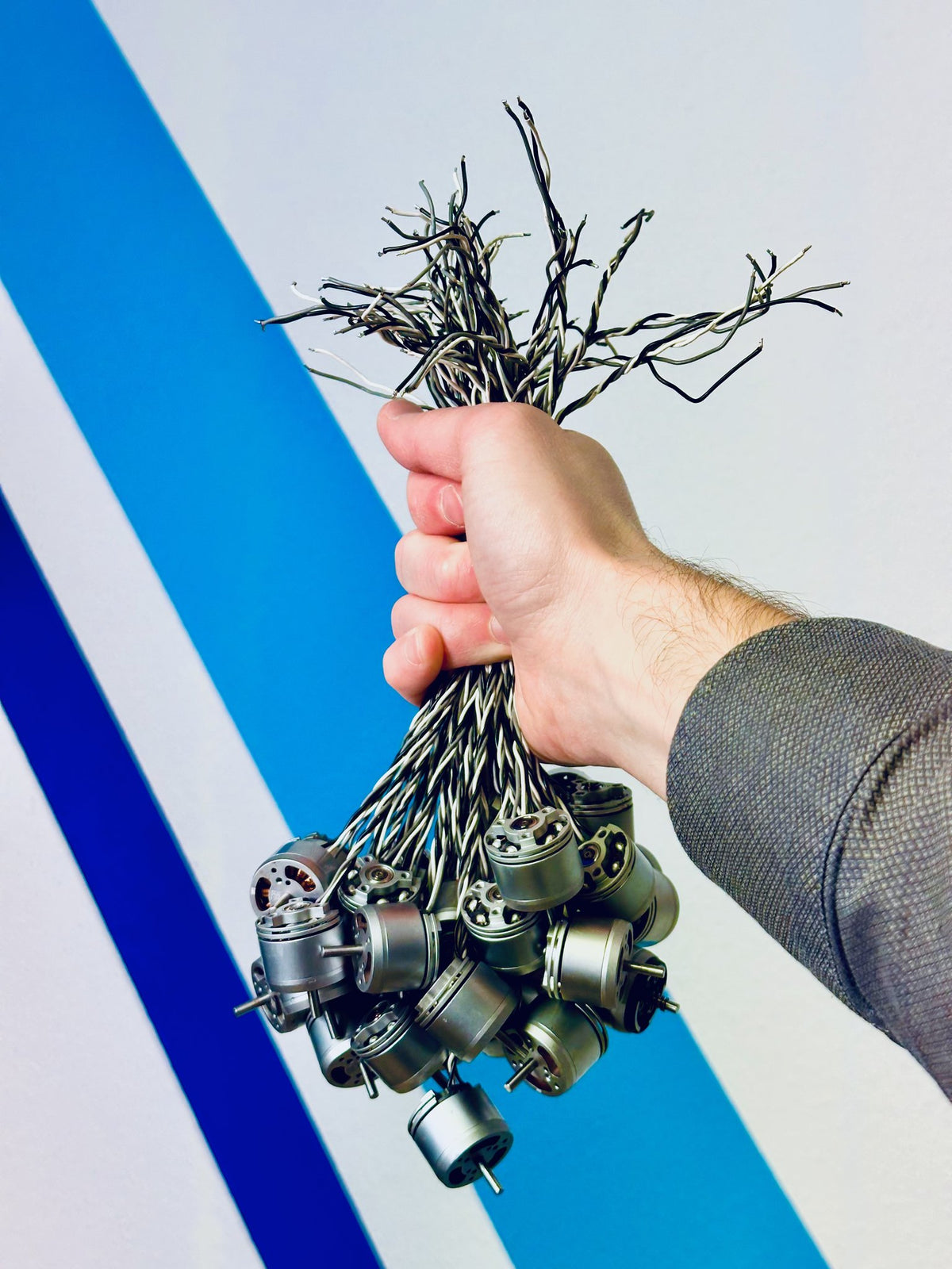 CopterTec-Mitarbeiter hält ein Bündel DJI Ersatzmotoren – Ersatzteile für Drohnenreparaturen direkt auf Lager.
